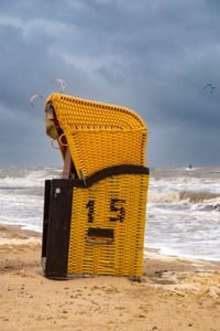 Strandkorb bei Sturmflut mit Kiter